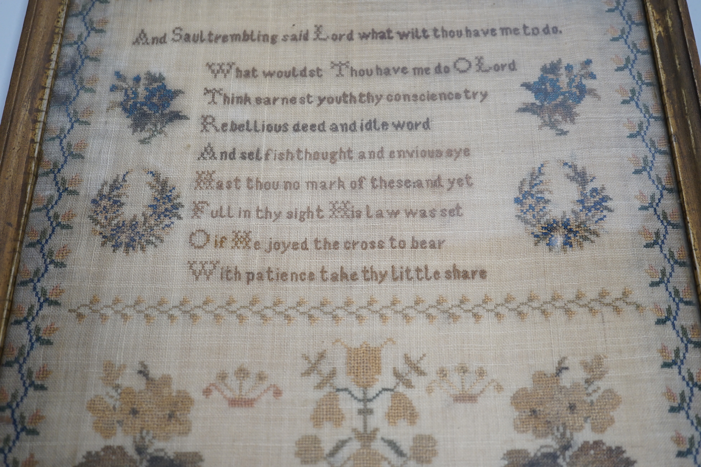A mid 19th century framed sampler worked by Hannah Clarice, aged 13, 1853, embroidered with a verse and flowers, overall 42cm x 35cm
